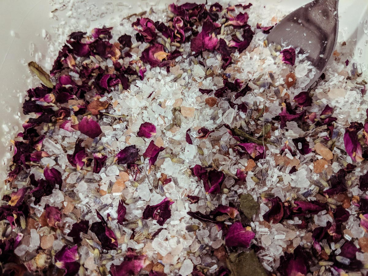 Bath salt blend: a mix of salts and herbs/florals in a silver bowl